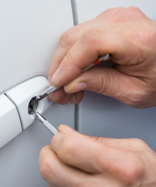 Close-up Of Person Hand Holding Lockpicker To Open Car Door